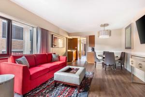 a living room with a red couch and a table at Hilton Club The District Washington DC in Washington