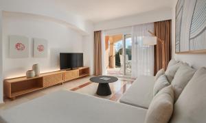 a living room with a couch and a tv at Grupotel Gran Vista & Spa in Can Picafort