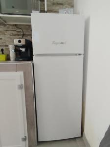 a white refrigerator in a kitchen next to a tv at La casa di Teresa in Taranto