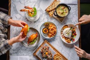 a table topped with plates of food with people eating at Hyatt Regency London Blackfriars in London