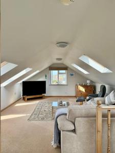 a living room with a couch and a flat screen tv at The Surf House (Widemouth Bay) in Bude