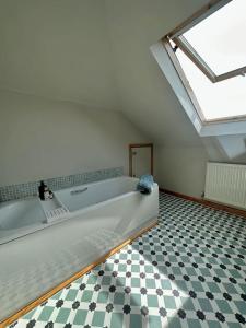 a large white bath tub in a room with a checkered floor at The Surf House (Widemouth Bay) in Bude
