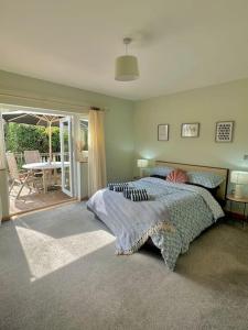 a bedroom with a bed and a patio with a table at The Surf House (Widemouth Bay) in Bude +21 photos