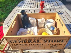 a wooden box with a bottle and cups on a table at Jade room in Saint-Romain-Lachalm