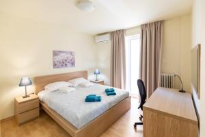 a bedroom with a bed and a desk with two blue bags on it at Athens Kyniska Urban Apartment in Athens