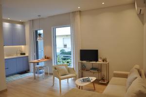sala de estar con sofá, mesa y cocina en Athens Sea Front Apartment - Athenian Riviera en Varkiza