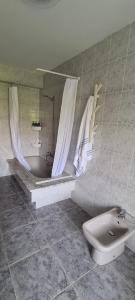 een badkamer met een bad, een toilet en een wastafel bij Vento Nordés in Malpica