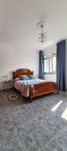 een slaapkamer met een groot houten bed in een kamer bij Vento Nordés in Malpica