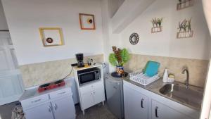 a small kitchen with a sink and a microwave at Warm sunset, Loft by the sea in La Libertad