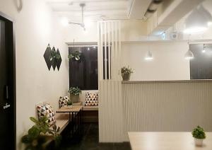 台北市にあるCOZY Homeのテーブルと椅子、鉢植えの植物が備わる部屋