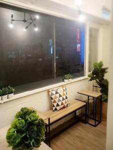a bench sitting in front of a window with plants at COZY Home in Taipei
