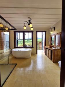 a large bathroom with a large tub and windows at Pousada Dom Xavier in Tiradentes