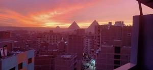 a view of the pyramids in a city at sunset at pyramids stone Top in Cairo