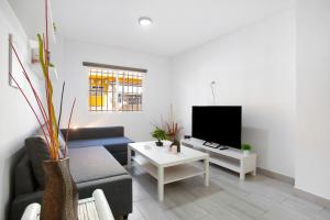 a living room with a couch and a tv at Casa Alex Prieto 3 Habitaciones in Puerto del Rosario