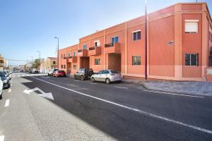 una strada con auto parcheggiate sul lato di un edificio di Casa Alex Prieto 3 Habitaciones a Puerto del Rosario