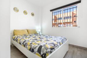 Cama en habitación blanca con ventana en Casa Alex Prieto 3 Habitaciones, en Puerto del Rosario
