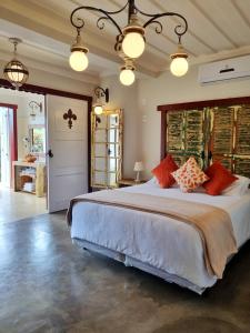 a large bedroom with a large bed with orange pillows at Pousada Dom Xavier in Tiradentes