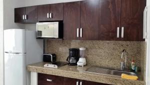 a kitchen with a counter with a sink and a microwave at Cancun Studio overlooking the Lagoon in Cancún