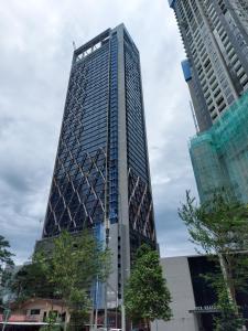 un edificio alto de cristal en una ciudad con dos edificios altos en Scarletz Suites KLCC by GC Luxury Suites, en Kuala Lumpur