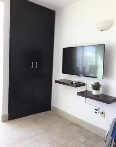 a living room with a tv and a black door at Cancun Studio overlooking the Lagoon in Cancún