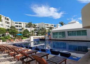 a swimming pool with lounge chairs and a resort at Cancun Studio overlooking the Lagoon in Cancún