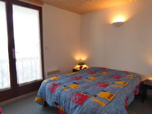 a bedroom with a bed with a quilt on it at Appartement Saint-Lary-Soulan, 3 pièces, 6 personnes - FR-1-457-243 in Saint-Lary-Soulan