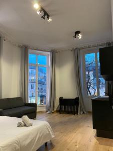 a bedroom with a bed and a couch and windows at Studio Grand Rex in Paris