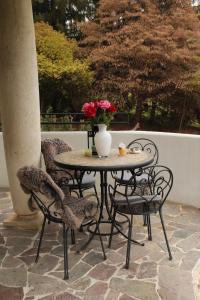 a table and chairs with a vase of flowers on a patio at Villa Jasmine in Arcugnano