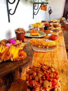 a table full of different types of food on plates at Pousada Dom Xavier in Tiradentes