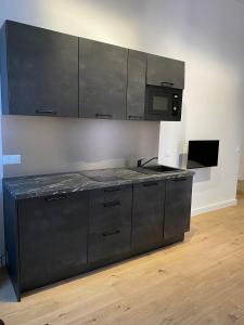 a black kitchen with a stove and a microwave at Studio Grand Rex in Paris