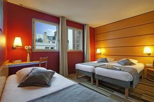 a hotel room with two beds and a window at Belambra Clubs & Hotels - Le Magendie in Paris +37 photos