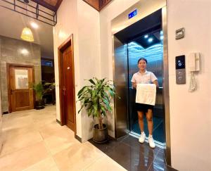 a woman standing in a elevator in a building at Le Vert Angkor Hotel in Siem Reap