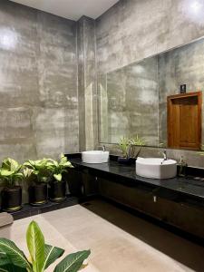 a bathroom with two sinks and potted plants at Le Vert Angkor Hotel in Siem Reap