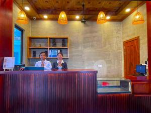 two people sitting at a bar in a restaurant at Le Vert Angkor Hotel in Siem Reap