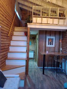 a staircase leading up to a room with a table at Mini Casa de Troncos en el Sur in San Martín de los Andes