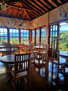 ein Esszimmer mit Tischen, Stühlen und Fenstern in der Unterkunft Pousada Dom Xavier in Tiradentes