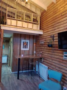 Mini Casa de Troncos en el Sur في سان مارتين دي لوس أندس: بار في غرفة مع جدران خشبية