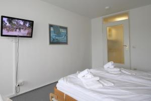 a room with two beds and a tv on the wall at Haus Sylter Welle 9-92a OB in Westerland (Sylt)