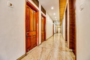an empty hallway with wooden doors and a tile floor at FabHotel Manjeet in Bhopal