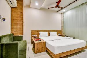 una camera da letto con un letto e una sedia verde di FabHotel Prime Manjeet a Bhopal