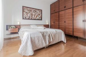 1 dormitorio con 1 cama grande y armarios de madera en Il lago di Diana, en Mandello del Lario