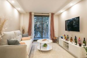 Una sala de estar con un sofá y un televisor. en YOUR HOME - Camp Nou Apartment, en Hospitalet de Llobregat