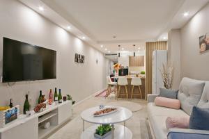 Una sala de estar con un sofá y un televisor en una pared. en YOUR HOME - Camp Nou Apartment, en Hospitalet de Llobregat