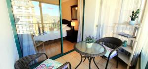 balkon ze stołem i krzesłami oraz pokój w obiekcie Depto frente a la playa Av Jorge Montt w mieście Viña del Mar