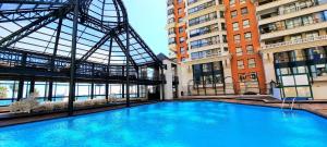 duży basen w budynku z wysokimi budynkami w obiekcie Depto frente a la playa Av Jorge Montt w mieście Viña del Mar