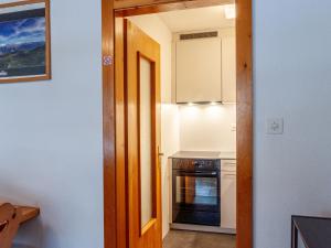 a small kitchen with a stove and a oven at Apartment Muverans I B1 by Interhome in Nendaz