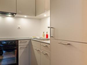 una cucina con frigorifero e lavandino di Apartment Muverans I B1 by Interhome a Nendaz