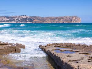 a view of the ocean from a rocky beach at Apartment Menorca-3 by Interhome in Balcon del Mar