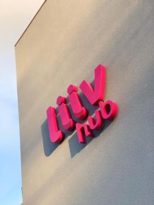 a pink hush sign on the side of a building at Liiv Hub in Natal