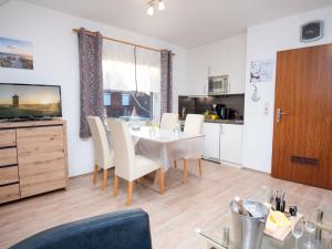 eine Küche und ein Esszimmer mit Tisch und Stühlen in der Unterkunft Apartment Blinkfeuer by Interhome in Norddeich